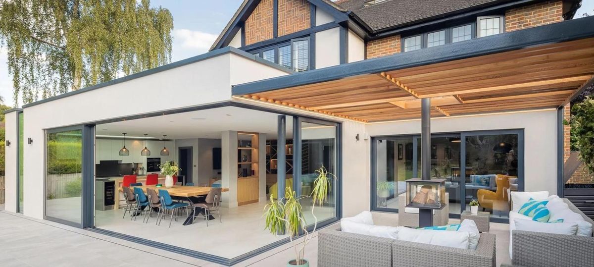 A rear extension with large aluminium sliding doors and a timber pergola